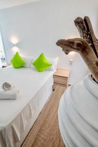 a bedroom with a white bed with green pillows at Villa N15 en plein cœur de la Marina, proche de Rosas, Costa Brava in Empuriabrava