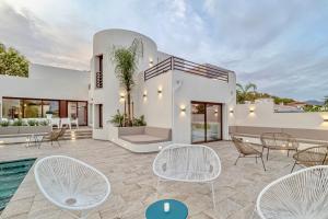 a white house with a pool and chairs at Villa N15 en plein cœur de la Marina, proche de Rosas, Costa Brava in Empuriabrava