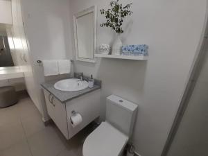 Baño blanco con aseo y lavamanos en Kent Manor Guest Suites, en Johannesburgo