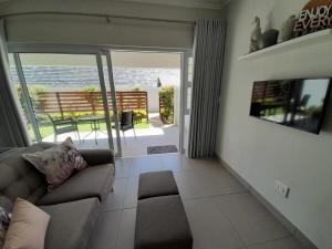 uma sala de estar com um sofá e uma varanda em Kent Manor Guest Suites em Joanesburgo