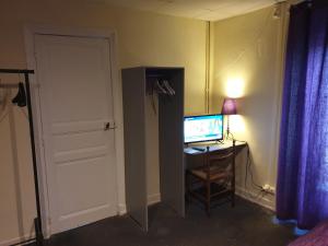 een kamer met een bureau met een computer en een deur bij Hotel au Pont d'Anjou in La Guerche-de-Bretagne