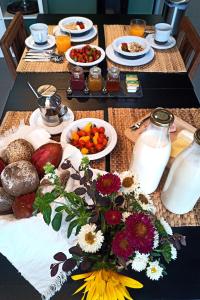 une table avec des assiettes de nourriture, des fruits et du lait dans l'établissement Verde Água Agroturismo e Agricultura Biológica, à Couto