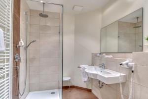 
a bathroom with a shower, sink, and toilet at Hotel Alt Vellern in Beckum
