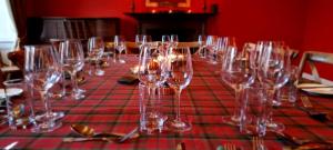 una mesa con copas de vino en un mantel rojo en Buccleuch and Queensberry Arms Hotel, en Thornhill