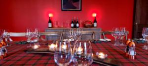 een rode kamer met een tafel met wijnglazen bij Buccleuch and Queensberry Arms Hotel in Thornhill