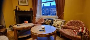 a living room filled with furniture and a fire place at Buccleuch and Queensberry Arms Hotel in Thornhill