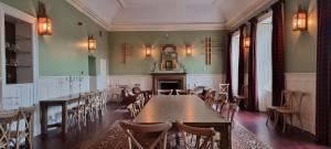 a dining room with tables and chairs and a fireplace at Buccleuch and Queensberry Arms Hotel in Thornhill