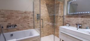 a bathroom with a tub, sink and shower at Buccleuch and Queensberry Arms Hotel in Thornhill