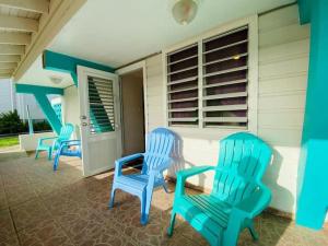 drie blauwe stoelen op de veranda van een huis bij Free WIFI 1st Floor Apartment in Punta Santiago