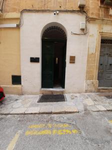 a building with a green door on the side of it at CA1- City Central Apartment 1 in Valletta