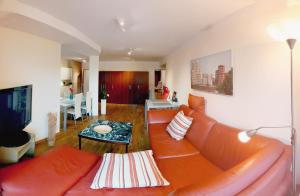 een woonkamer met een oranje bank en een tafel bij City-Apartment 65qm 2-Schlafzimmer WLAN Nichtraucher Parken in Düsseldorf