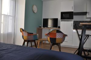 1 dormitorio con 2 sillas, mesa y cocina en Segré centre ✰ studio ✰ 24m² ✰ cuisne ✰ wifi ✰ TOUT NEUF!, en Segré