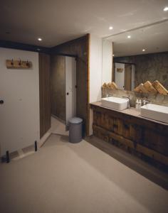 a bathroom with two sinks and a mirror at The Lake District Bunkbarn, Ings in Kendal