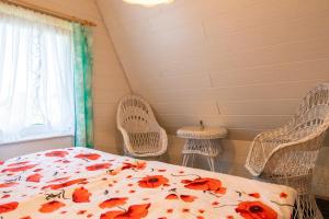 a bedroom with a bed and two chairs and a window at Ferienhaus Boddenkieker in Freest