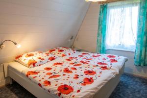 a bedroom with a bed with red flowers on it at Ferienhaus Boddenkieker in Freest