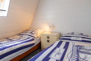 a bedroom with two beds and a dresser and a window at Ferienhaus Boddenkieker in Freest