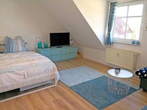 Schlafzimmer mit einem Bett, einem TV und einem Tisch in der Unterkunft Ferienwohnung Utkiek - Ruhe und Erholung in Heringsdorf