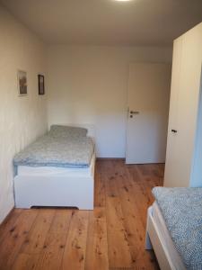 een slaapkamer met 2 bedden en een houten vloer bij Ferienwohnung Dinkelbergblick in Wehr