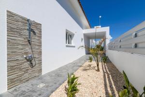 a white house with a retaining wall and plants at Villa Olivia in Xylophaghou