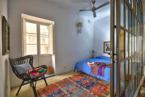 1 dormitorio con 1 cama, 1 silla y 1 ventana en ACG- Sea Breeze Apartment, en Floriana
