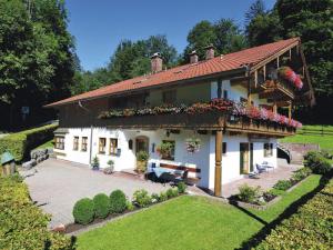 a large white house with flowers in the yard at Ferienwohnung Vogl in Berchtesgaden