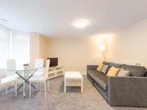 ein Wohnzimmer mit einem Sofa und einem Tisch in der Unterkunft Dartford Luxurious Apartment in Dartford