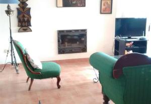 a living room with two chairs and a fireplace at Unique villa with magnificent views in Nerja