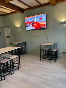 a room with tables and a tv on the wall at The Banks Of Ury in Inverurie