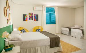 a bedroom with two beds and two chairs at Pousada Serra Bella in Tianguá +68 photos