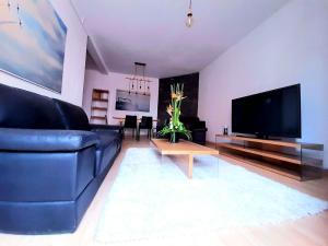 a living room with a blue couch and a tv at Cosy and Charming Home 2 in Antananarivo