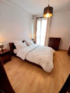 1 cama blanca grande en un dormitorio con ventana en Cosy and Charming Home 2, en Antananarivo