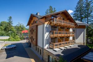 a house with a balcony on the side of it at Holiday Family in Szklarska Poręba