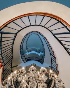 a chandelier in a room with a spiral staircase at Albergo Del Sole in Porto Valtravaglia