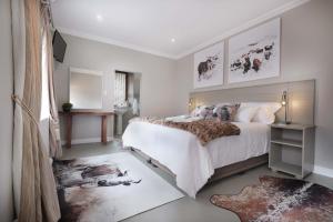 een slaapkamer met een groot bed met witte muren bij Adderley House Guest Accommodation in Robertson