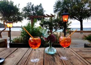 dos copas de vino sentadas sobre una mesa de madera en FACE MER ENTRE PLAGE ET MARINA, en Bormes-les-Mimosas