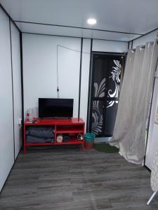 sala de estar con TV y mesa roja en Safar House & Cabin (Muslim), en Kuala Kangsar