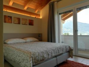 a bedroom with a bed and a large window at L'Atelier du Temps - A&G Apartment in Aosta