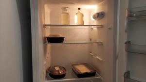 einem Kühlschrank mit zwei Flaschen und einem Handy darin in der Unterkunft Joan's airport apartment in Artemida