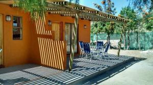 a patio with blue chairs and a house at Cabañas Stommeln in Ovalle