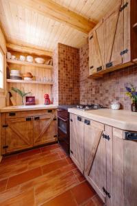 a kitchen with wooden cabinets and wooden floors at Chalet Orlica Velika Planina in Stahovica