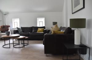 sala de estar con sofá negro y mesa en Typisch Norg, en Norg