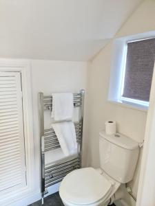 a bathroom with a white toilet and a window at Warsett Crescent, 5 bedrooms near the coast. in Skelton