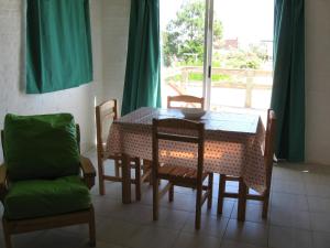 Un comedor con mesa y sillas y una ventana. en Altos de La Balconada, en La Paloma