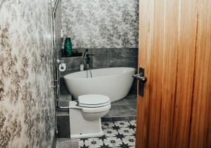 a bathroom with a tub and a toilet and a sink at The Peppermill Town house Hotel & Restaurant in Devizes