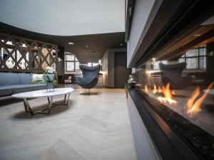 ヴィトレにあるLe Magic Hôtel & Spaのソファと暖炉のあるリビングルーム