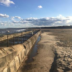 a retaining wall on a beach next to the ocean at “The Reach” Lovely 2 bed house in Gorleston on Sea in Gorleston-on-Sea