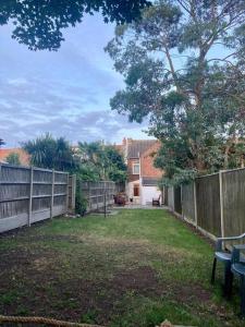 a yard with a fence and a bench and a house at “The Reach” Lovely 2 bed house in Gorleston on Sea in Gorleston-on-Sea