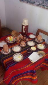einen Tisch mit Platten und Hüten darüber in der Unterkunft Hostal Indigo Urubamba in Urubamba