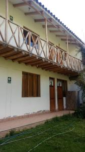 ein Haus mit einem Holzbalkon darüber in der Unterkunft Hostal Indigo Urubamba in Urubamba