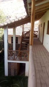 eine Veranda eines Hauses mit einem Holzdach in der Unterkunft Hostal Indigo Urubamba in Urubamba